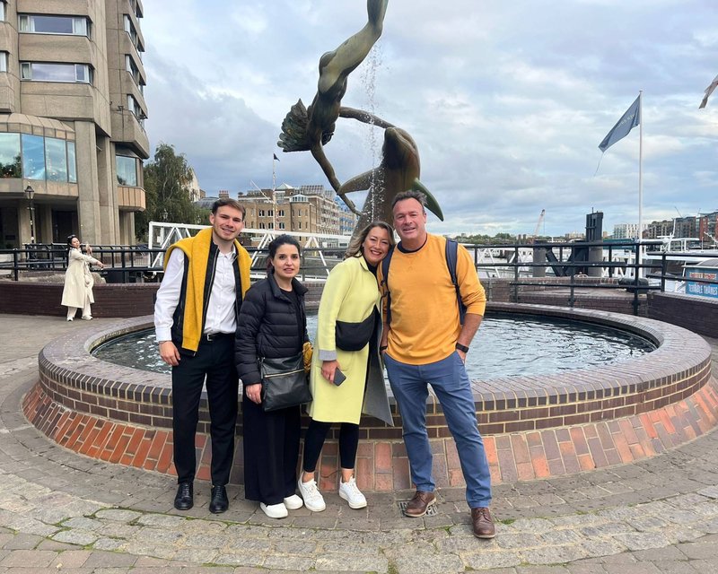 Race Across The World: The Experience Team standing with girl with dolphin statue near Tower Bridge