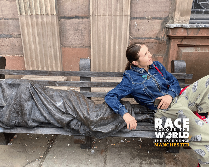 Player posing with homeless Jesus statue Race Across The World the experience